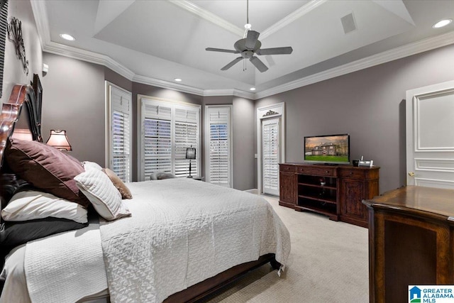 carpeted bedroom featuring a raised ceiling, ceiling fan, and crown molding