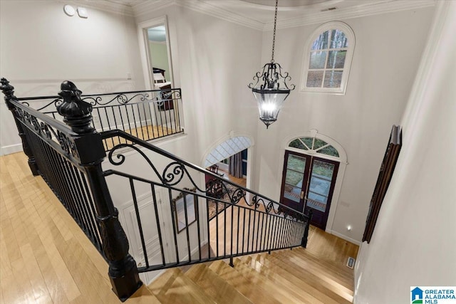 stairway featuring crown molding, french doors, and hardwood / wood-style flooring