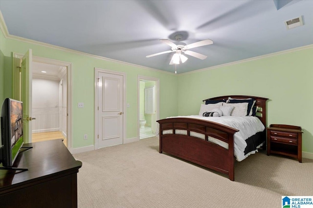 bedroom with ceiling fan, ornamental molding, light carpet, and ensuite bath