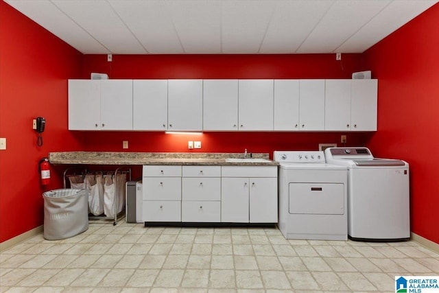 laundry room featuring cabinets, sink, and washing machine and clothes dryer