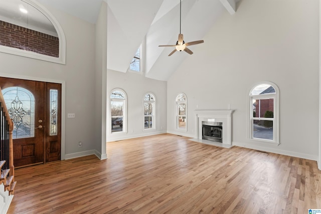 foyer with ceiling fan, light hardwood / wood-style flooring, and a high ceiling