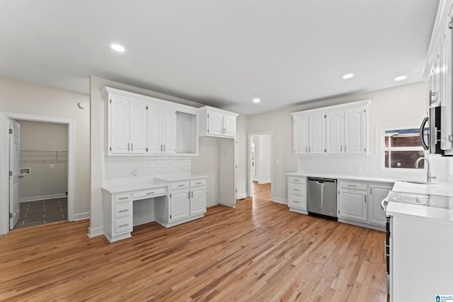 kitchen with dishwasher, sink, white cabinets, backsplash, and light wood-type flooring