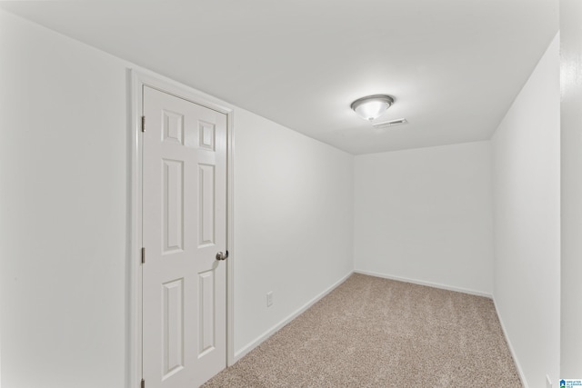 spare room featuring light colored carpet