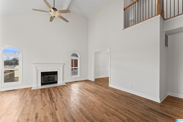 unfurnished living room featuring ceiling fan, high vaulted ceiling, and hardwood / wood-style flooring