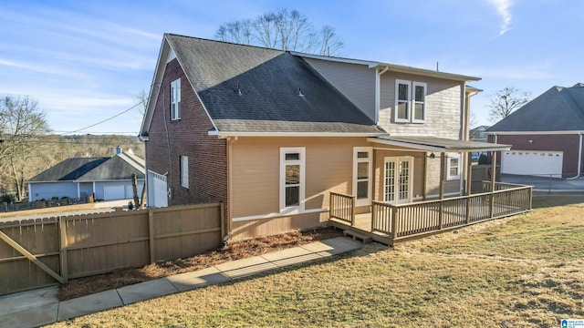 back of house with a lawn and a deck