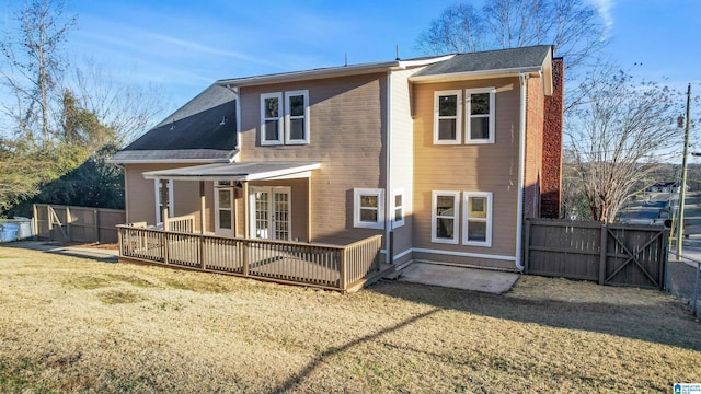 rear view of property with a wooden deck and a lawn