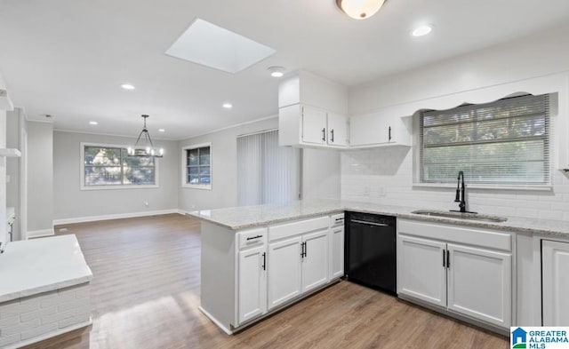 kitchen with a skylight, sink, wood-type flooring, dishwasher, and white cabinetry