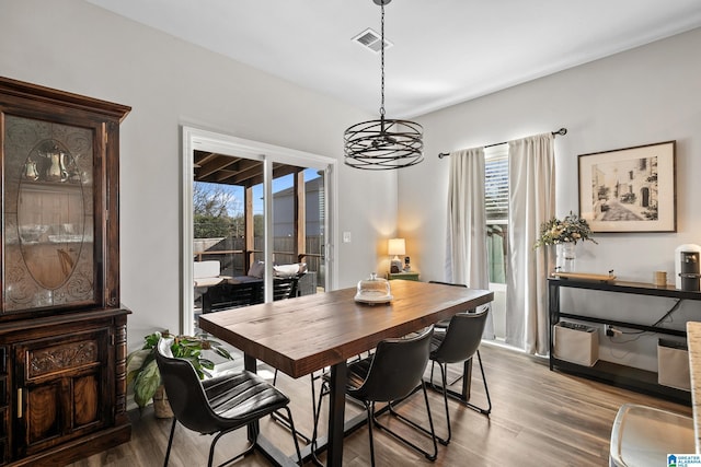 dining room with hardwood / wood-style floors and a chandelier