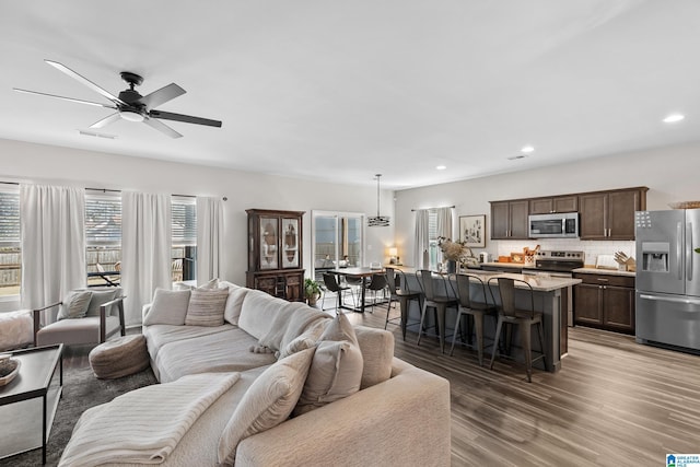 living room with ceiling fan and dark hardwood / wood-style floors