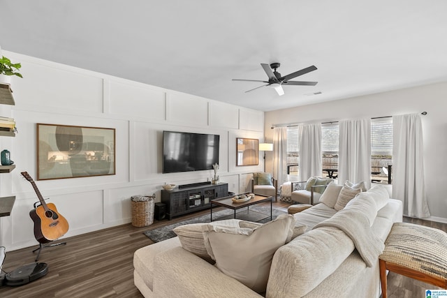 living room with ceiling fan and dark hardwood / wood-style flooring