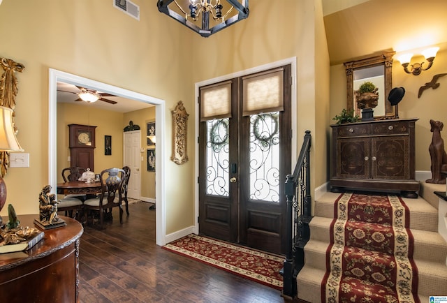 foyer entrance featuring french doors, ceiling fan with notable chandelier, and dark hardwood / wood-style floors