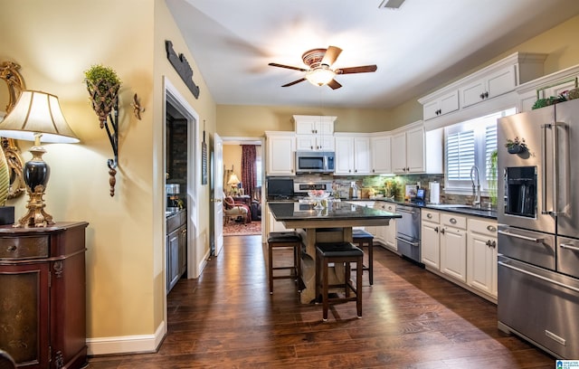 kitchen featuring backsplash, sink, white cabinets, and appliances with stainless steel finishes