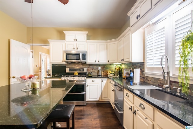 kitchen with white cabinets, appliances with stainless steel finishes, backsplash, and sink