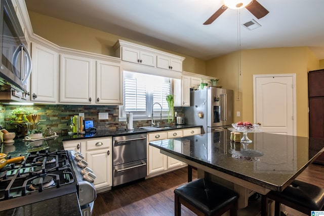 kitchen with white cabinetry, sink, appliances with stainless steel finishes, and dark stone counters