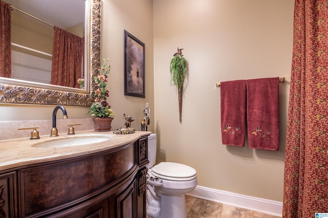 bathroom featuring tile patterned flooring, vanity, and toilet