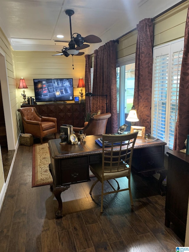 interior space featuring ceiling fan, dark hardwood / wood-style flooring, and wooden walls