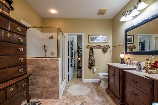 bathroom with vanity, an enclosed shower, and toilet