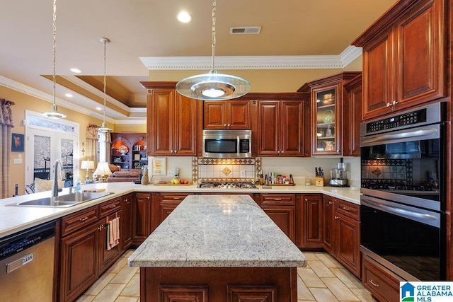 kitchen with pendant lighting, a kitchen island, sink, and stainless steel appliances