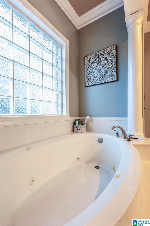 bathroom featuring a washtub, ornate columns, and crown molding