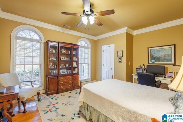 bedroom with ceiling fan, crown molding, and light wood-type flooring