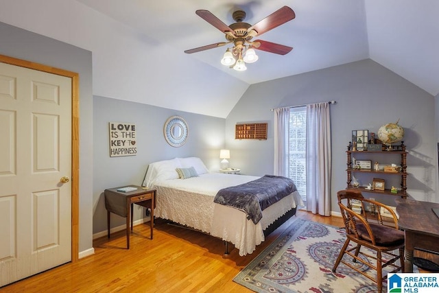 bedroom with light wood-type flooring, vaulted ceiling, and ceiling fan