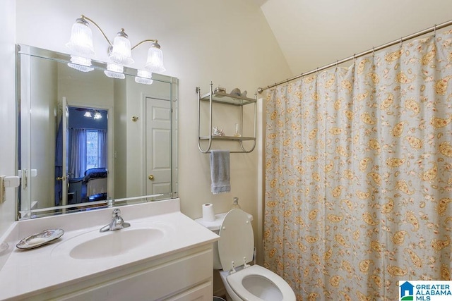 bathroom with vanity, toilet, and vaulted ceiling