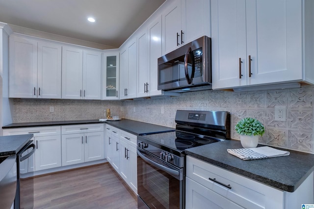 kitchen with decorative backsplash, appliances with stainless steel finishes, light hardwood / wood-style floors, and white cabinetry