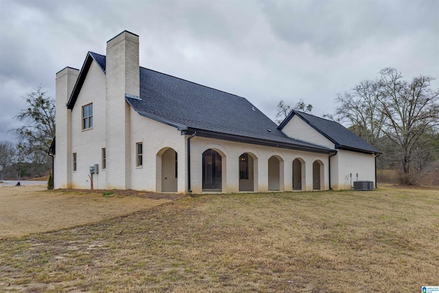 back of house featuring a lawn and central AC