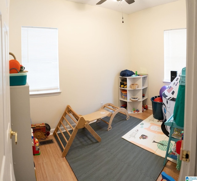 game room featuring wood-type flooring and ceiling fan