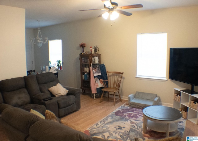 living room featuring hardwood / wood-style flooring, ceiling fan with notable chandelier, and a wealth of natural light