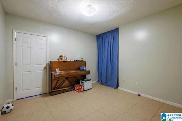 miscellaneous room with light tile patterned flooring and a textured ceiling