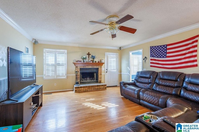 living room featuring a textured ceiling, plenty of natural light, crown molding, and light hardwood / wood-style flooring