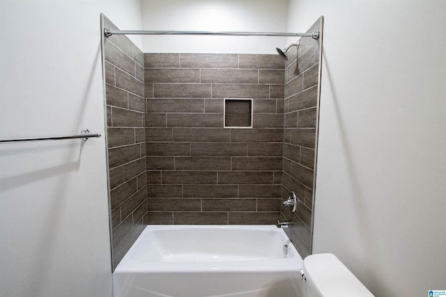 bathroom with toilet and tiled shower / bath