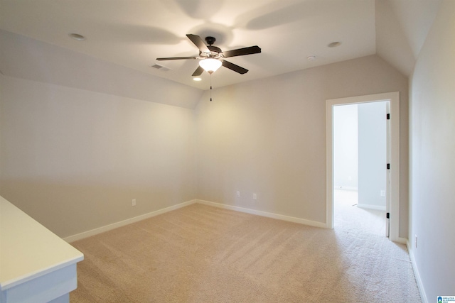 carpeted empty room with ceiling fan and vaulted ceiling