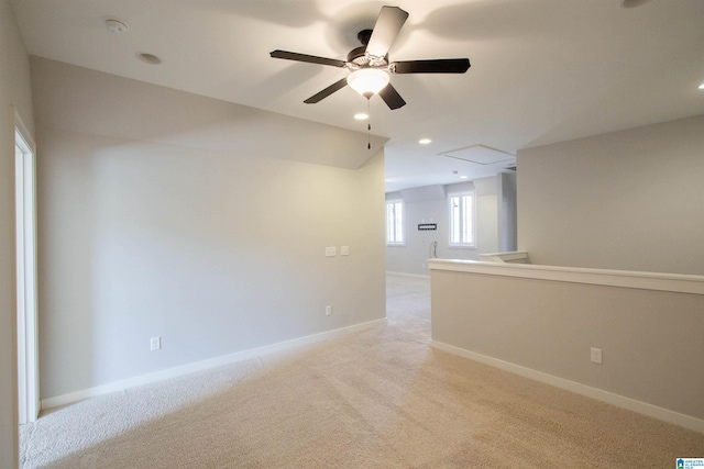 empty room featuring light carpet, ceiling fan, and vaulted ceiling