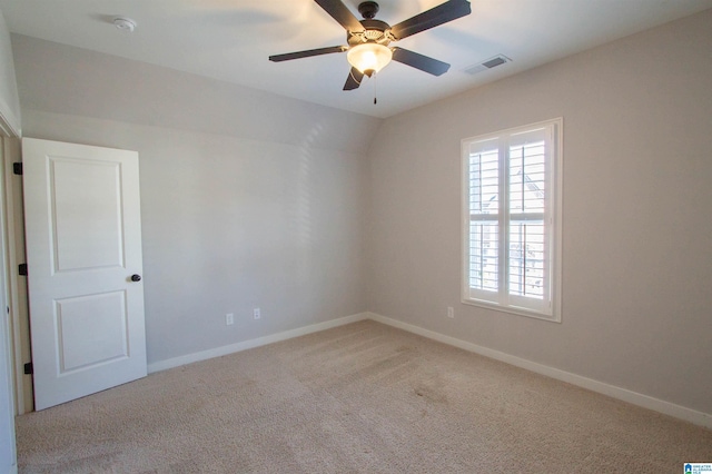 carpeted spare room with ceiling fan and lofted ceiling