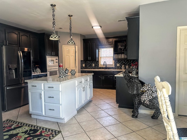 kitchen with decorative backsplash, white appliances, sink, a center island, and white cabinetry