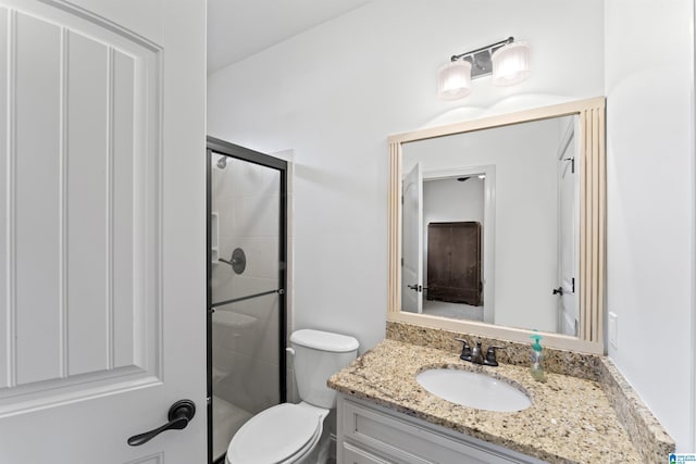 bathroom with toilet, an enclosed shower, and vanity