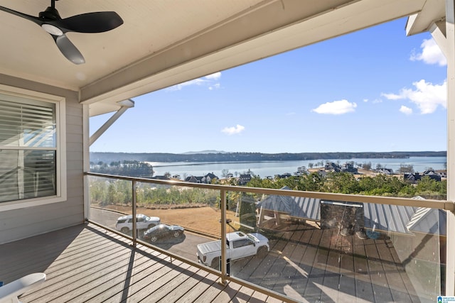 balcony with ceiling fan and a water view