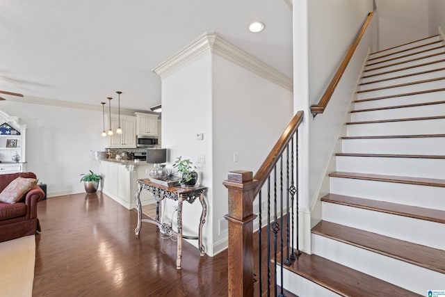 stairway featuring crown molding and hardwood / wood-style floors