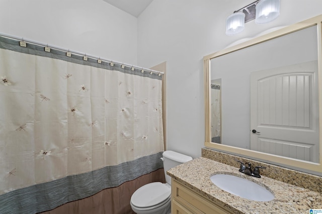 bathroom featuring curtained shower, vanity, and toilet