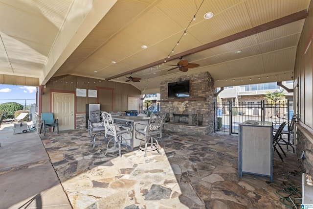 view of patio / terrace with ceiling fan and an outdoor stone fireplace