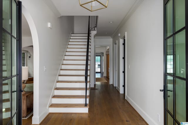 entryway with dark hardwood / wood-style floors, crown molding, and plenty of natural light