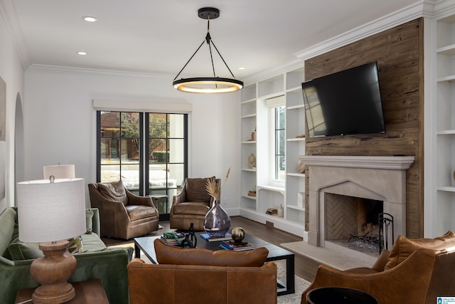 living room featuring a high end fireplace, crown molding, built in features, and light hardwood / wood-style flooring