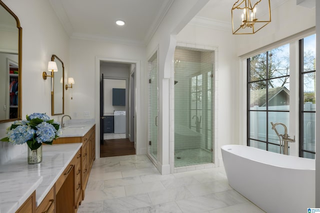 bathroom featuring washer / clothes dryer, crown molding, vanity, separate shower and tub, and an inviting chandelier