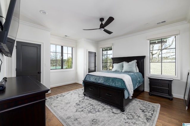 bedroom featuring dark hardwood / wood-style flooring, multiple windows, ceiling fan, and ornamental molding