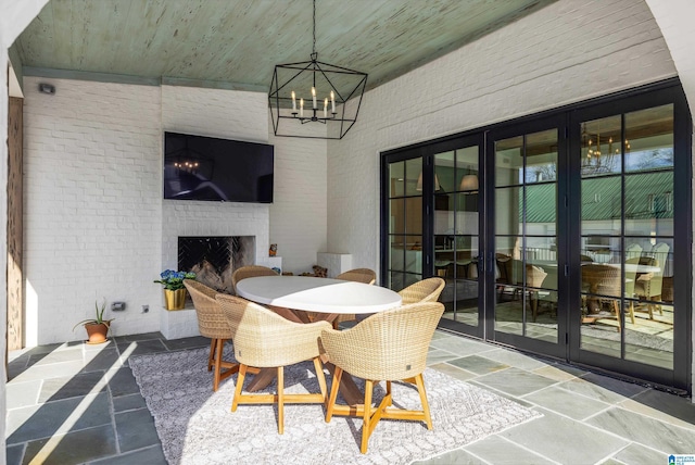 interior space with an outdoor brick fireplace and french doors