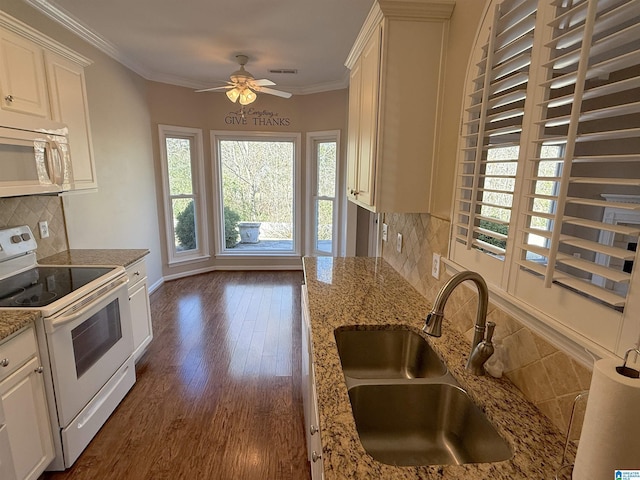 kitchen featuring white appliances, backsplash, white cabinets, sink, and ornamental molding