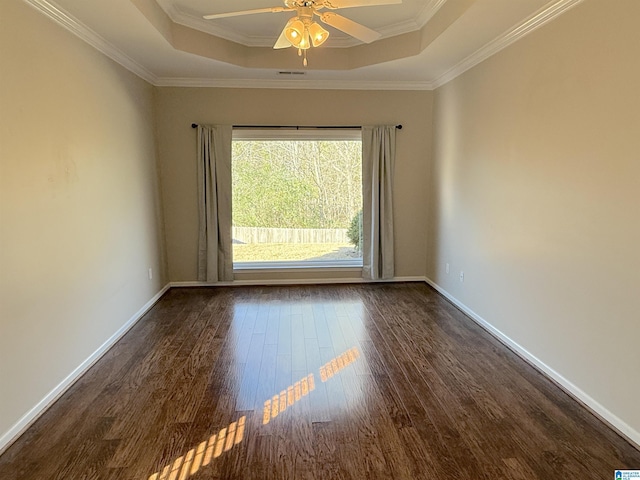 empty room featuring dark hardwood / wood-style floors, a raised ceiling, ceiling fan, and crown molding