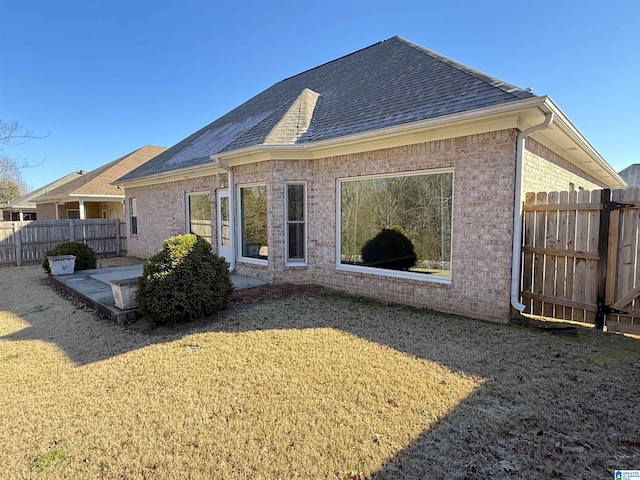 back of house featuring a patio area and a yard